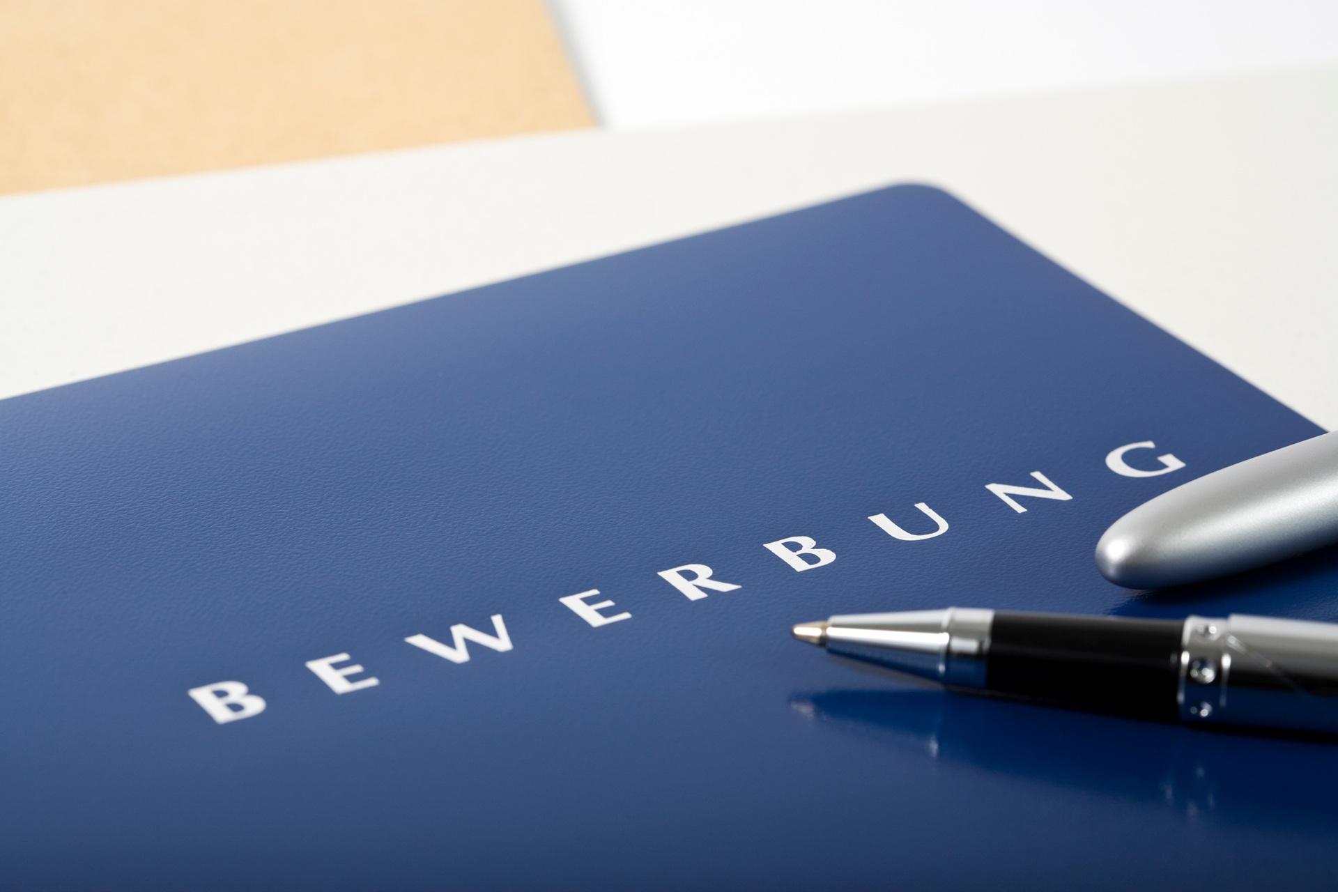 Blaue Bewerbungsmappe mit Stift | Jobs Logopädie Düsseldorf