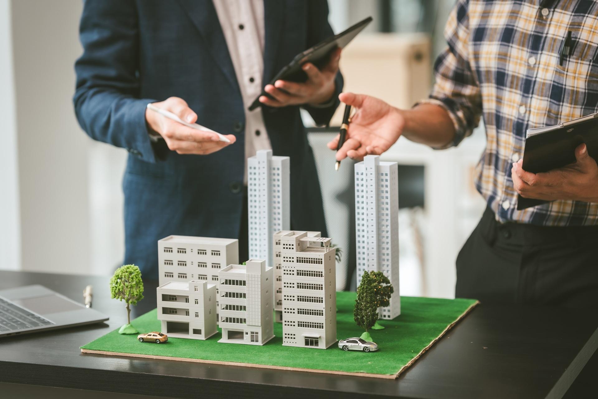 Architekten besprechen Baupläne mit Gebäudemodellen | Straßenreparatur
